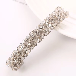 Macro detail of elegant hair clip with grey crystal flower arrangement on metal spring base