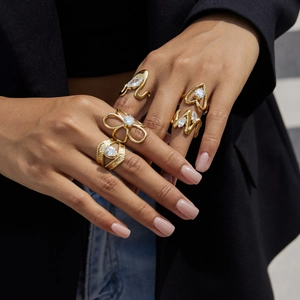 Vista detallada de set de anillos dorados con circonitas en mano con estilo urbano