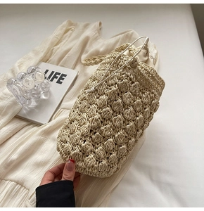 Close-up of popcorn knit weave texture on minimalist cream crochet bucket bag