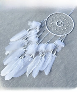Detail of white dream catcher featuring star weave net and soft natural feathers