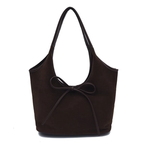 Detail of soft dark brown suede tote bag with elegant bow knot and fine stitching