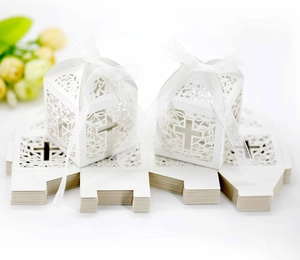 White laser-cut cross favor box with pearl paper finish and silk ribbon detail