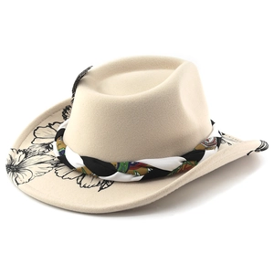 Detail of wool felt fedora featuring black floral brim patterns and a colorful woven band