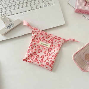 Close-up of heart leopard print canvas drawstring pouch with pink ribbon and brand label