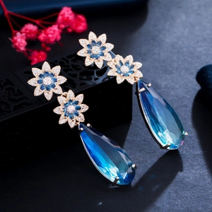 Elegant gold flower earrings with blue teardrop sapphire and sparkling zircon crystals