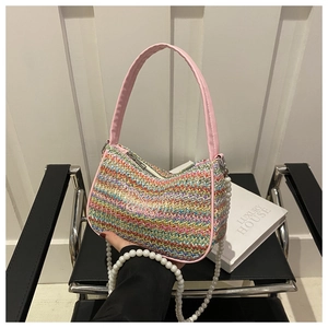 Détail du sac en paille tissé à la main avec rayures colorées et papillon brodé rose