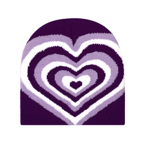 Macro detail of purple and white heart pattern on warm winter knitted beanie cap
