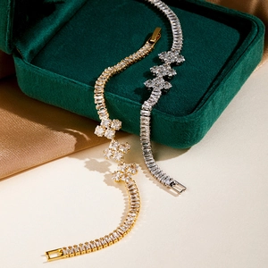 Detailed macro of gold and silver zircon bracelets with clover charms on velvet