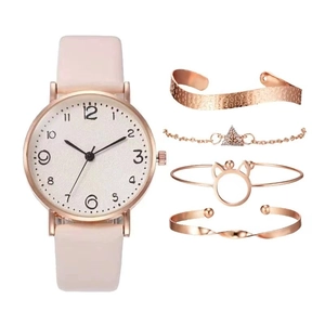 Coffret montre quartz à bracelet rose et quatre bracelets en or rose sur fond blanc