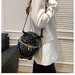 Detailed macro view of the glossy black owl shaped crossbody bag with 3D embossed scales