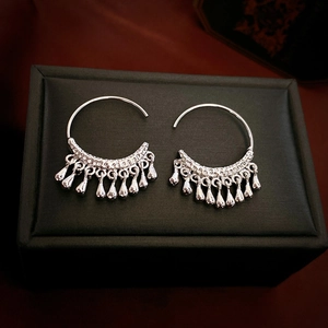 Silver C-shape hoop earrings with water drop fringe tassels on jewelry box