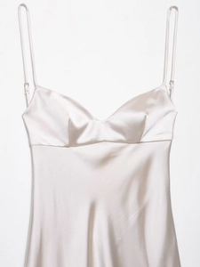 Detailed view of champagne satin dress fabric texture and delicate V-neck strap design