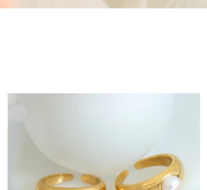 Detail of vintage gold open ring set featuring a glossy band and a white pearl accent