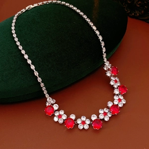 Detail of red flower pendant necklace displayed on a green velvet jewelry box
