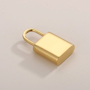 Detailed close-up of a polished gold stainless steel lock pendant charm on a textured background