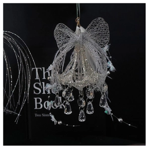 Detailed view of a silver mesh bow ornament with white feathers and crystal droplets