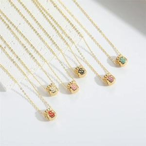 Gold money bag necklace with colorful dollar sign pendants on a white stone background