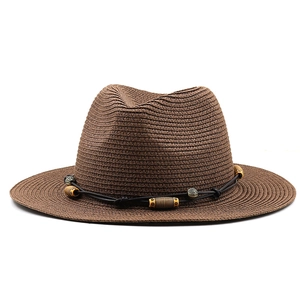 Détail du chapeau de paille marron foncé avec cordon noir et perles en bois ethniques