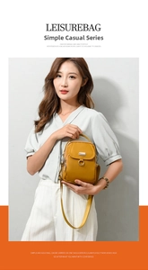 Detail view of mustard yellow cross-body bag with top handle and metal ring hardware decoration