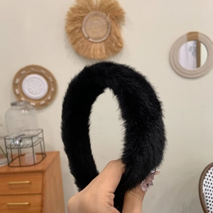 Gros plan d'un serre-tête doux en fausse fourrure noire montrant sa texture pelucheuse