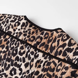 Detail of leopard print quilted jacket showing collar and black trim shoulder stitching