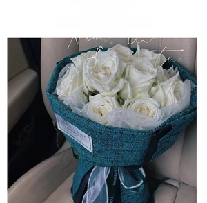 Detail of bouquet with white roses in dark green tweed and pearl fish tail mesh ribbon