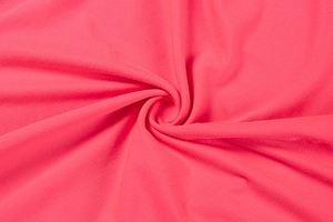 Detailed macro view of the rose red knitted fabric with soft texture and elegant drape