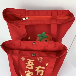 Detail of red canvas wedding bags showing zipper closure and snap button opening