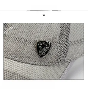 Macro detail of breathable mesh fabric and black metal eagle badge on light grey baseball cap