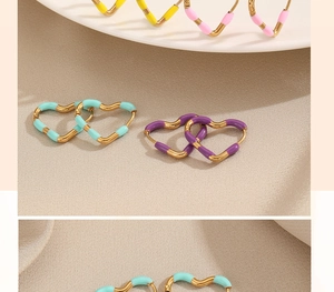 Detail shot of heart-shaped earrings in various pastel colors on a beige fabric background