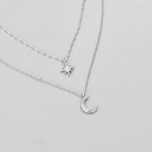 Elegant double-layered silver necklace featuring shimmering star and crescent moon pendants