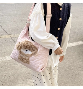 Detail of pink quilted tote bag with brown plush puppy embroidery and fabric texture