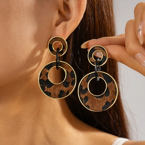 Detail of leopard print flocking double circle earrings with golden metal borders on model