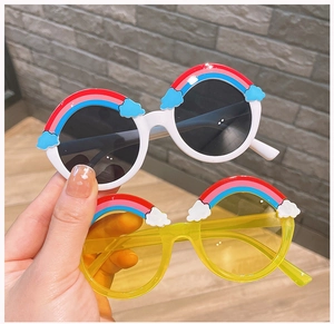 Detail of round kids sunglasses with cute 3D rainbow and cloud decorations on the frames