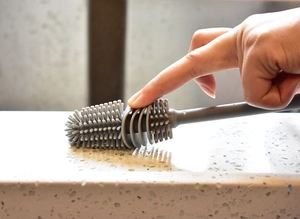 Dettaglio della testina flessibile in silicone grigio premuta per mostrare l'elasticità morbida