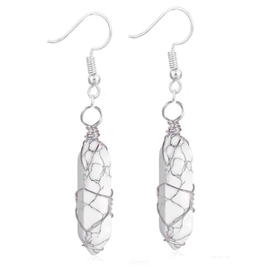 Detailed macro view of white turquoise hexagonal pendant earrings with silver wire wrapping