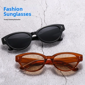 Close-up of cat-eye sunglasses featuring vintage metal rivet details and polished frames