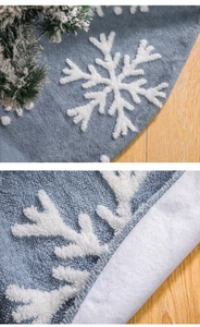 Detail of blue Christmas tree skirt with white snowflake embroidery and plush texture