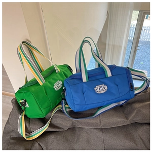 Detailed view of green and blue sports duffel bags with striped straps and logo