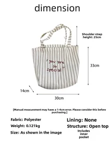 Detailed view of striped canvas tote bag with red script embroidery and dimensions