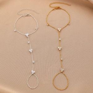 Detailed view of bohemian gold and silver hand chains with rhinestones on silk fabric