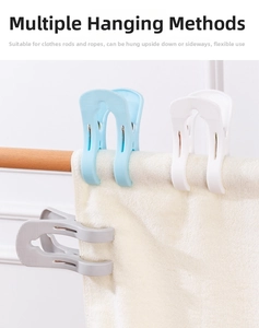 Detail showing various hanging angles of large windproof plastic quilt clips on a rod
