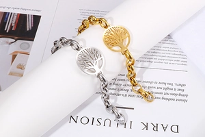 Dettagli di bracciali albero della vita argento e oro su una rivista di moda trendy