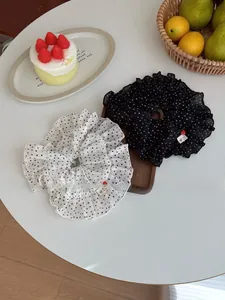 Polka dot scrunchies with heart buttons and handmade labels on a wooden tray