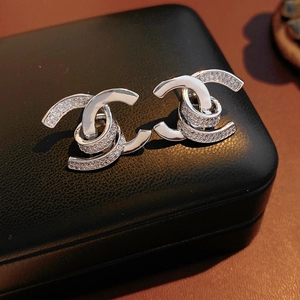 Detailed view of silver-tone double C earrings with zircon pavé set in a jewelry box