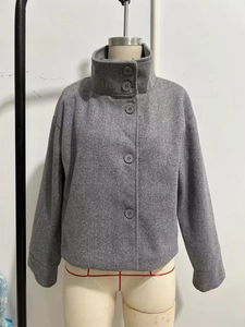 Détail du col montant et des grands boutons sur la veste grise en laine mélangée