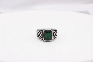 Close-up of vintage Viking signet ring featuring green gemstone and Celtic knot patterns