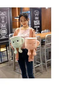 Close-up of cute coffee cup plush toys in green and pink in a cozy cafe setting