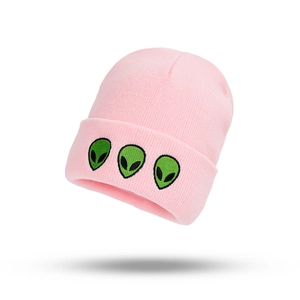 Close-up of pink ribbed beanie featuring three green alien head embroideries on fold