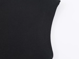 Detailed macro view of black knit fabric texture and high-quality stitching on midi dress